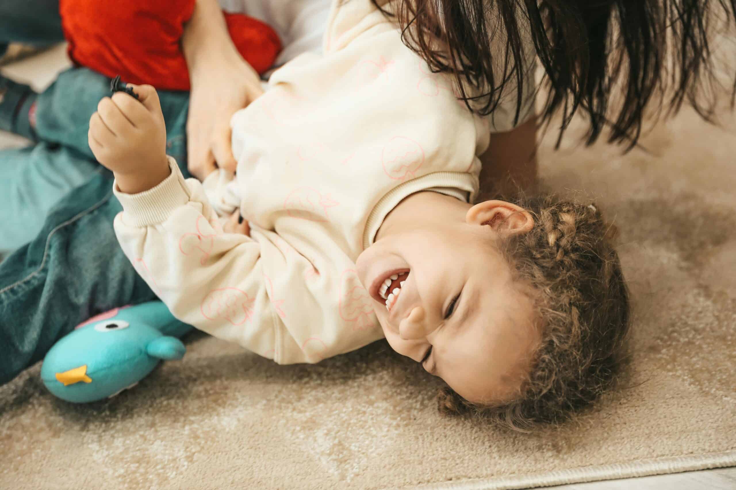 Photo d'un enfant qui rit car chatouillé