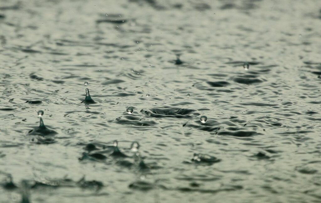 Photographie de gouttes de pluie tombant dans l'eau